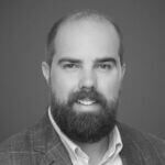 Rob is smiling and has a mustache and beard