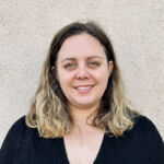 Sabrina has blonde hair and is wearing a black shirt